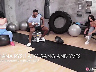 Hot milf gets a three-way with black studs in the gym