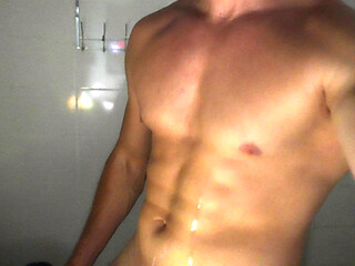 A muscular guy shows his dick in the shower