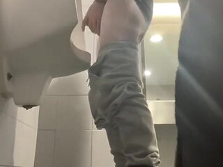 2 Boys in Sneakers Having Fun at Public Toilets' Urinal