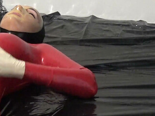 Photoshooting in Red Latex Catsuit with Latex Mask and Transparent Face.