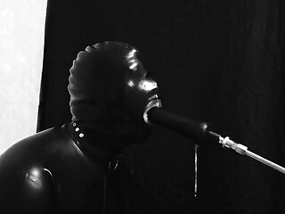 Rubber gimp train is throat with fuck machine