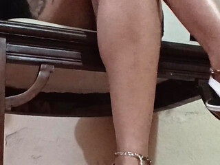 Her Long Legs Are Crossed, and Her High Heels Dangle From Her Feet as She Sips a Delicious Cup of Coffee