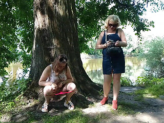 Two girls stopped on the side of the road to pee, attracting the attention of passing cars, golden shower in a public place