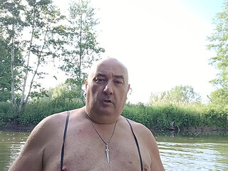 The plump, mustachioed daddy is having a blast in the stream, shamelessly masturbating with mud