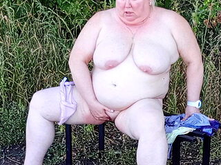Stepmom in the park undressing and masturbating on a bench