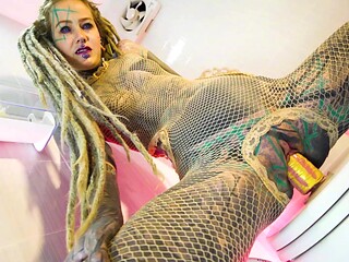 Tattooed beauty fingers and pees hard in fishnet stockings
