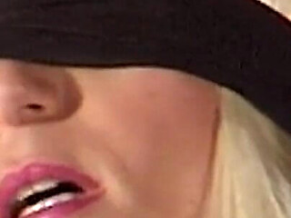Mature Dominatrix Oversees Masked Man with Bound Blonde
