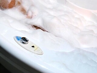 Beautiful blonde seductively teases her tits in a bubble bath