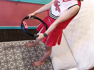 A married woman in a sexy cheerleader costume does some exercise as a