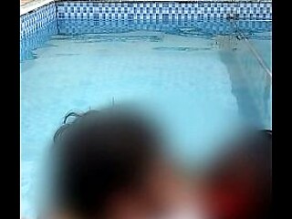 Couple makes out and enjoys a dip in the pool with their big butts touching.
