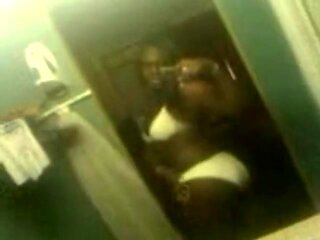 Black shemale in a bikini records herself in a mirror