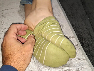 She slowly takes off her socks while I film her