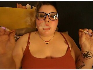 Chubby hippie smokes two cigarettes at once, savoring the burn