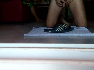 John is peeing on the bathing slippers on the floor