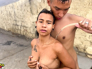 Young girl taking a hose bath in the backyard and dancing funk
