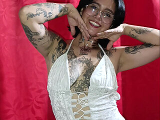 Tattooed Latin woman, black heels plays modeling